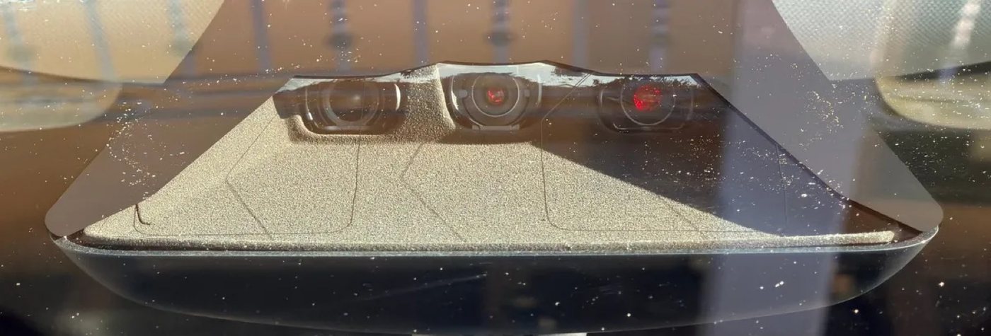 HW4 front windshield camera cluster — red-tinted lenses