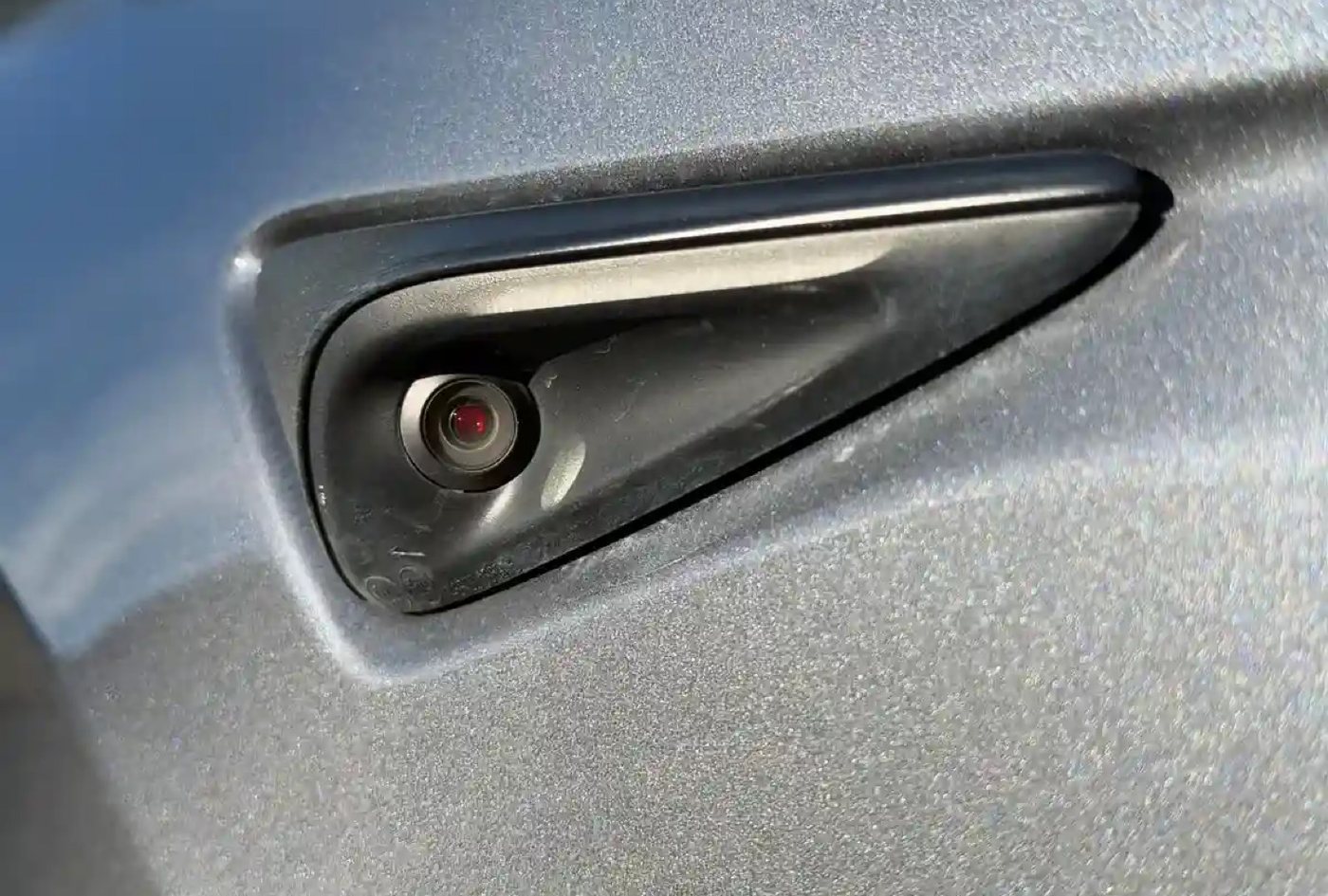 HW4 B-pillar side repeater — red-tinted lens on silver paint